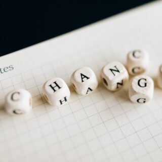 A Close-Up Shot of Letter Dice on an Open Notebook