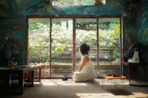 A woman sitting in a room with a window