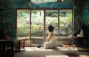 A woman sitting in a room with a window